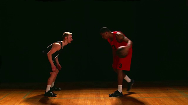篮球运动员在黑色背景下防守对手视频下载