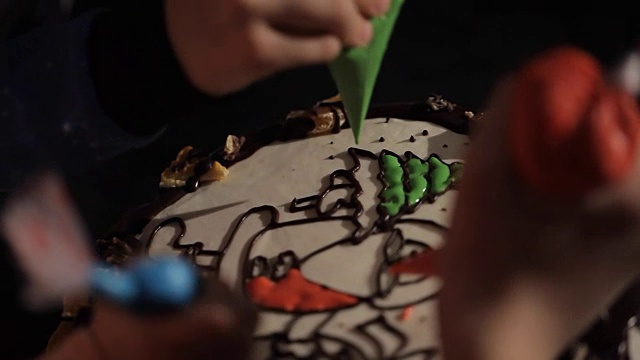 孩子们的手近距离从糕点袋挤压奶油蛋糕。视频素材