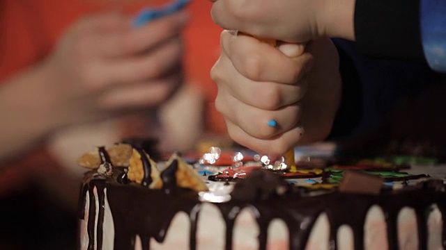 孩子们的手近距离从糕点袋挤压奶油蛋糕。视频素材