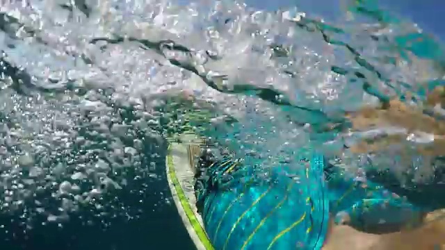 慢动作上下:不认识的人划着冲浪板在海洋中视频素材