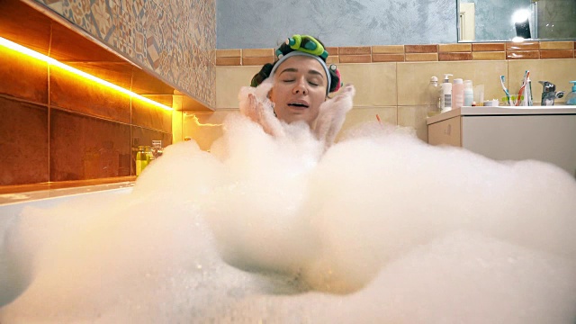 洗着泡沫浴玩着肥皂泡的漂亮女人。FullHD拍摄视频下载