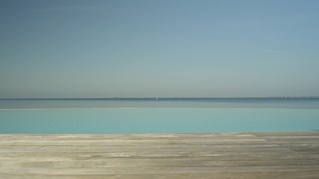 空中，近距离:浪漫的无边泳池俯瞰美丽的蓝色海洋视频素材