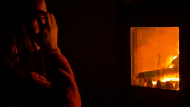 女孩在火炉旁沉思视频素材