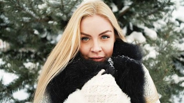 美丽的女孩在白雪覆盖的森林背景下微笑视频下载