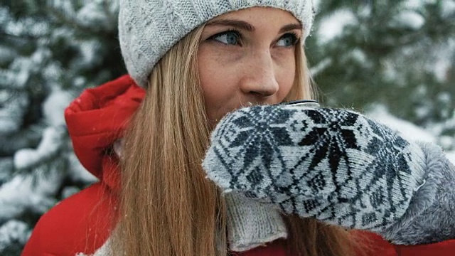 迷人的金发碧眼的热茶映衬着冬日的风景视频下载