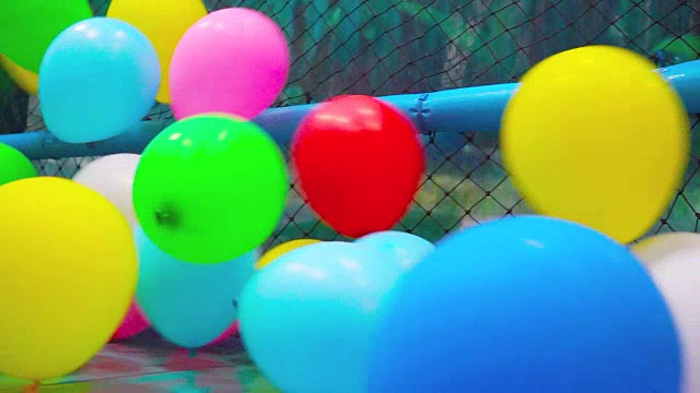 五颜六色的塑料气球在操场上吹。视频素材