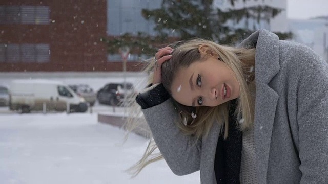 美丽的女孩在街上摆姿势在冬天视频下载