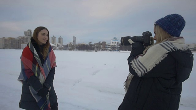 女孩在冬天的街道上拍摄她的朋友视频下载