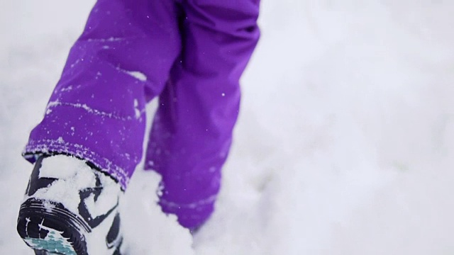 女孩穿着滑雪板鞋在雪地上行走视频下载