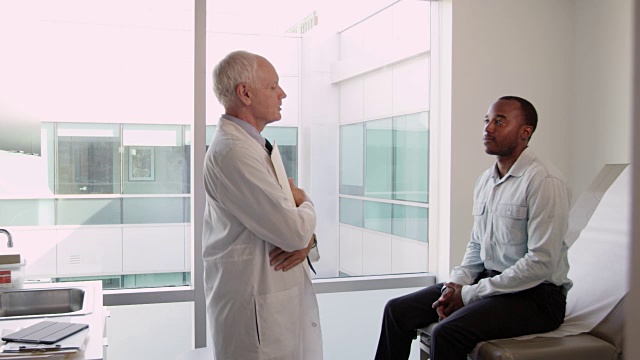 医生在检查室会见男性病人，拍摄于R3D视频素材