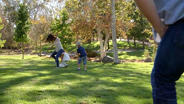 家庭在公园踢足球的慢动作序列视频素材