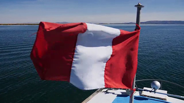 在秘鲁普诺地区的喀喀湖上航行的秘鲁国旗视频下载