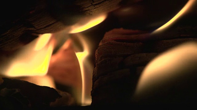 微距镜头的慢动作火焰燃烧木材。漂亮的镜头，你看到了飞舞的灰烬和舞动的火焰视频下载