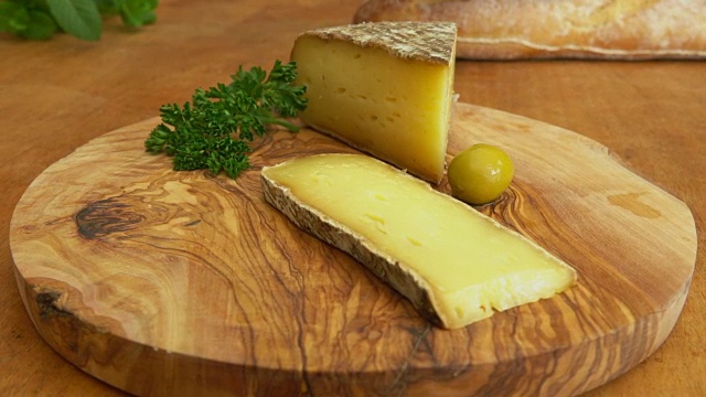 木板上放着硬奶酪，长棍面包和橄榄视频素材