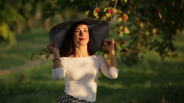 性感的女人与美丽的脸日光浴在温暖的夏季公园日落视频下载