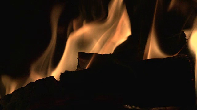 温暖的剪影拍摄的原木燃烧的火炉在行动视频下载