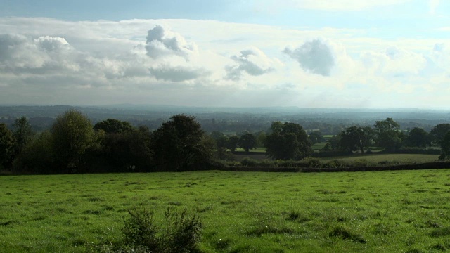 英国乡村，有新鲜的绿草，灌木篱墙和蓬松的云彩视频下载