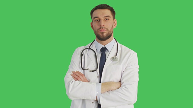 (中景)一个严肃的医生做停止手势，然后双手交叉放在胸前。拍摄发生与绿色屏幕背景。视频素材