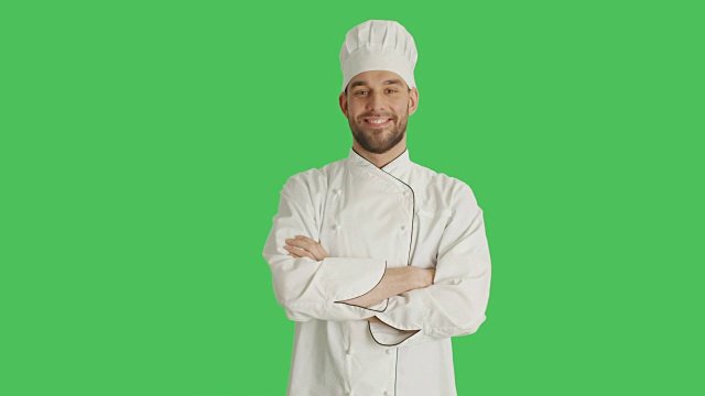 中景的一个英俊的厨师交叉他的胳膊和微笑。背景为绿幕。视频素材