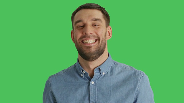 一个英俊的男人笑的中特写镜头。拍摄在一个绿色屏幕背景。视频素材