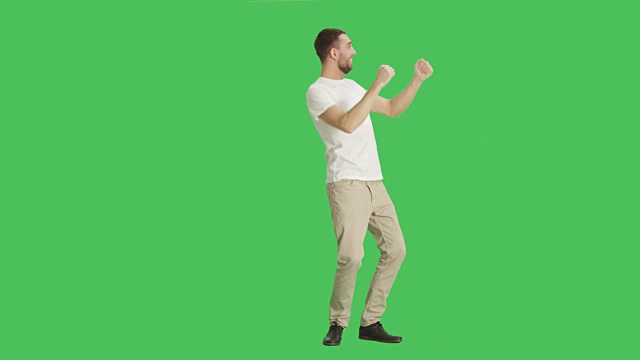 一个随意的人跳舞的长镜头。拍摄在一个绿色屏幕背景。视频素材