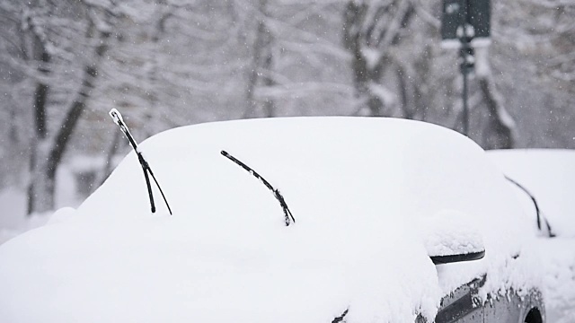 一辆被雪覆盖的汽车的挡风玻璃刮水器视频素材