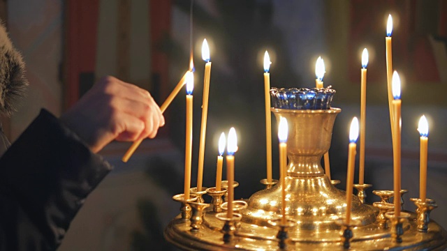 在东正教教堂里点燃蜡烛。图标和祈祷视频素材