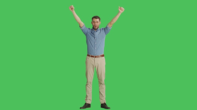 一个快乐随意的男人取得胜利，庆祝，成功的姿态。拍摄在一个绿色屏幕背景。视频素材