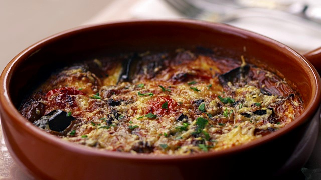 茄子，羊乳酪和番茄在陶器盘，平底锅中烘烤视频下载