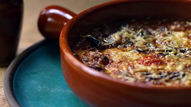 茄子、羊乳酪和番茄在陶器盘中烘烤，放大视频下载