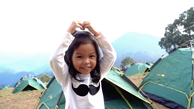 亚洲小女孩萨朗海哟运动在高山露营日。慢动作镜头视频下载