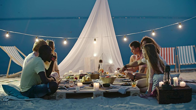 和朋友一起在海滩上享用美丽的晚餐视频素材