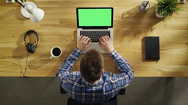 俯视图的年轻的创造性的人在他的绿色屏幕模拟笔记本旁边躺耳机，笔记本。视频素材