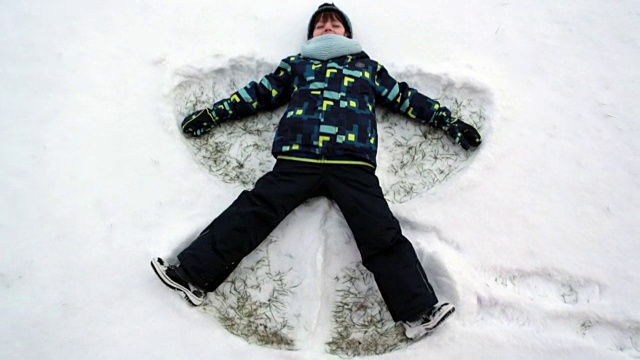小可爱，小男孩，躺在北极的雪地上，做雪天使，冬天的时候视频下载