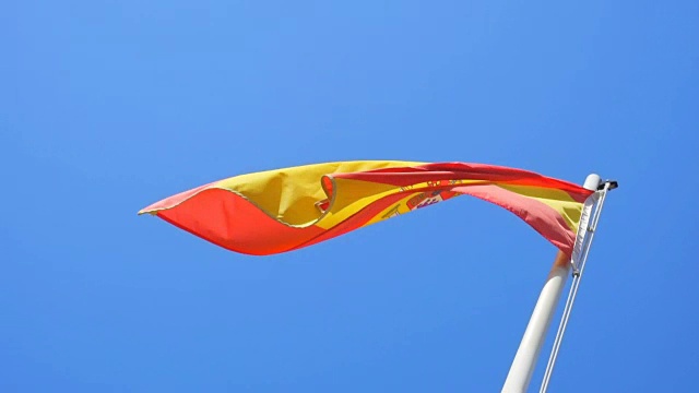 西班牙国旗飘扬在蓝天的背景下视频素材