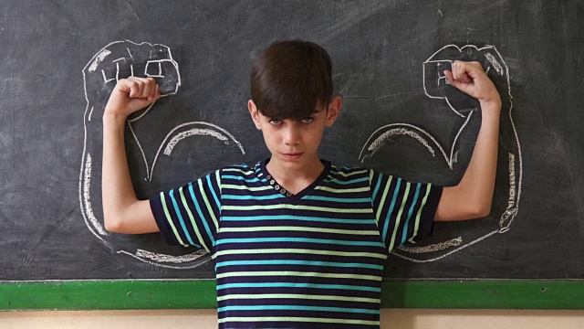 强壮的男孩在课堂上展示肌肉视频素材