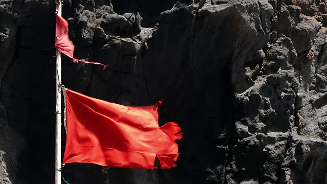 被风吹动的破碎红旗的特写。视频下载