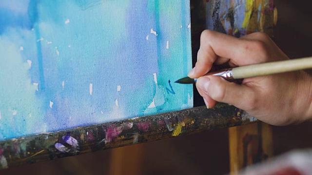 年轻的女艺术家画与水彩颜料和写她的签名完成特写视频下载