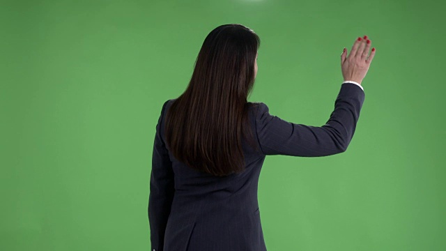女人的后视图遇到某人看手表，并在绿色屏幕上挥舞她的手视频下载