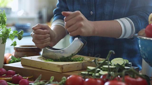 倾斜的女人用切菜刀切香菜的镜头视频素材