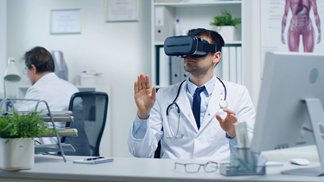 男医生戴着虚拟现实头盔进行实验性医疗程序。他的助手密切监视他的活动。办公室是轻便和超现代的。视频素材