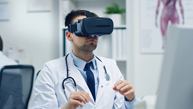 男医生戴着虚拟现实头盔进行实验性医疗程序。他的助手密切监视他的活动。现代是轻和超现代。视频素材