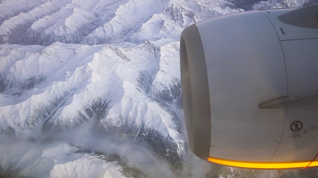 飞机引擎和被雪覆盖的阿尔卑斯山脉在日落视频素材