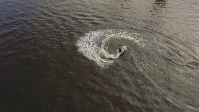 一个十几岁的男孩在河里玩水上摩托艇。航拍视频视频素材