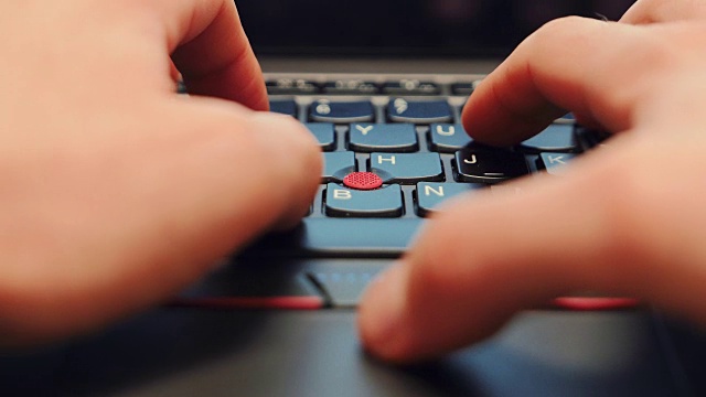一个年轻男性在笔记本电脑键盘上打字的超近距离镜头视频素材