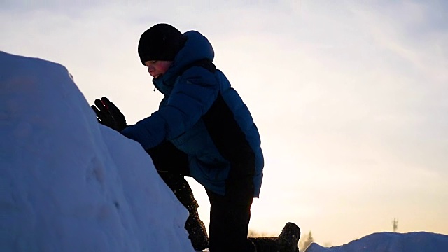 孩子们在雪山里玩耍，要爬到山顶。在日落时视频下载