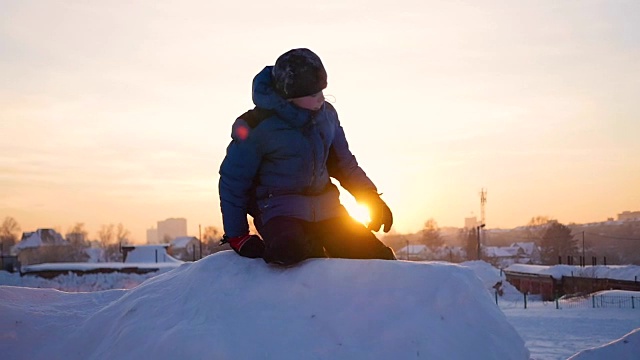 孩子们在雪山里玩耍，要爬到山顶。在日落时视频素材