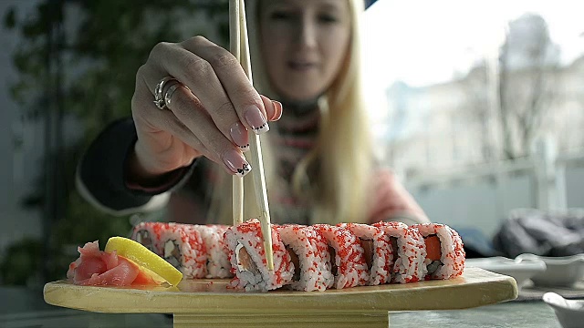 在日本餐馆用筷子吃寿司的女孩视频素材
