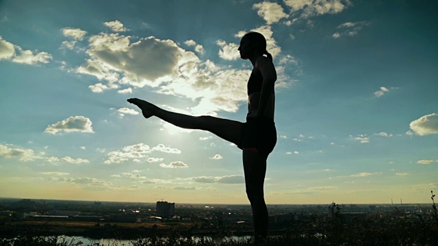 日落时分，一个女人在公园里练瑜伽视频下载