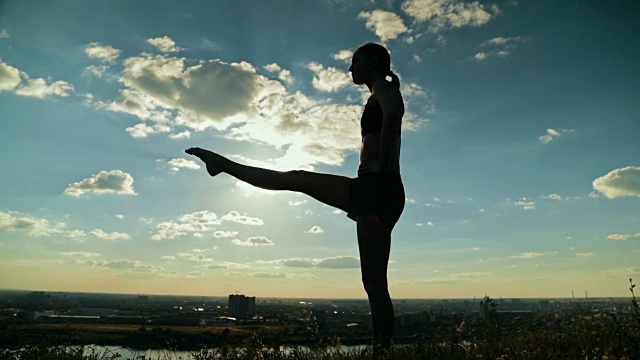日落时分，一个女人在公园里练瑜伽视频下载